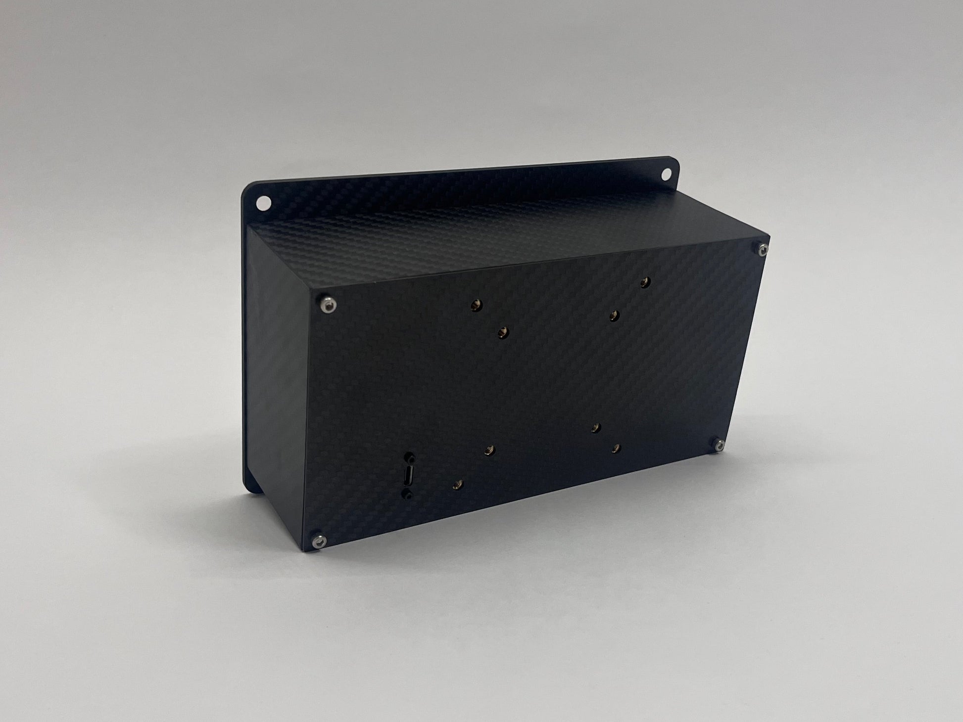 back of carbon fiber button box showing VESA mounts and USB input on grey background
