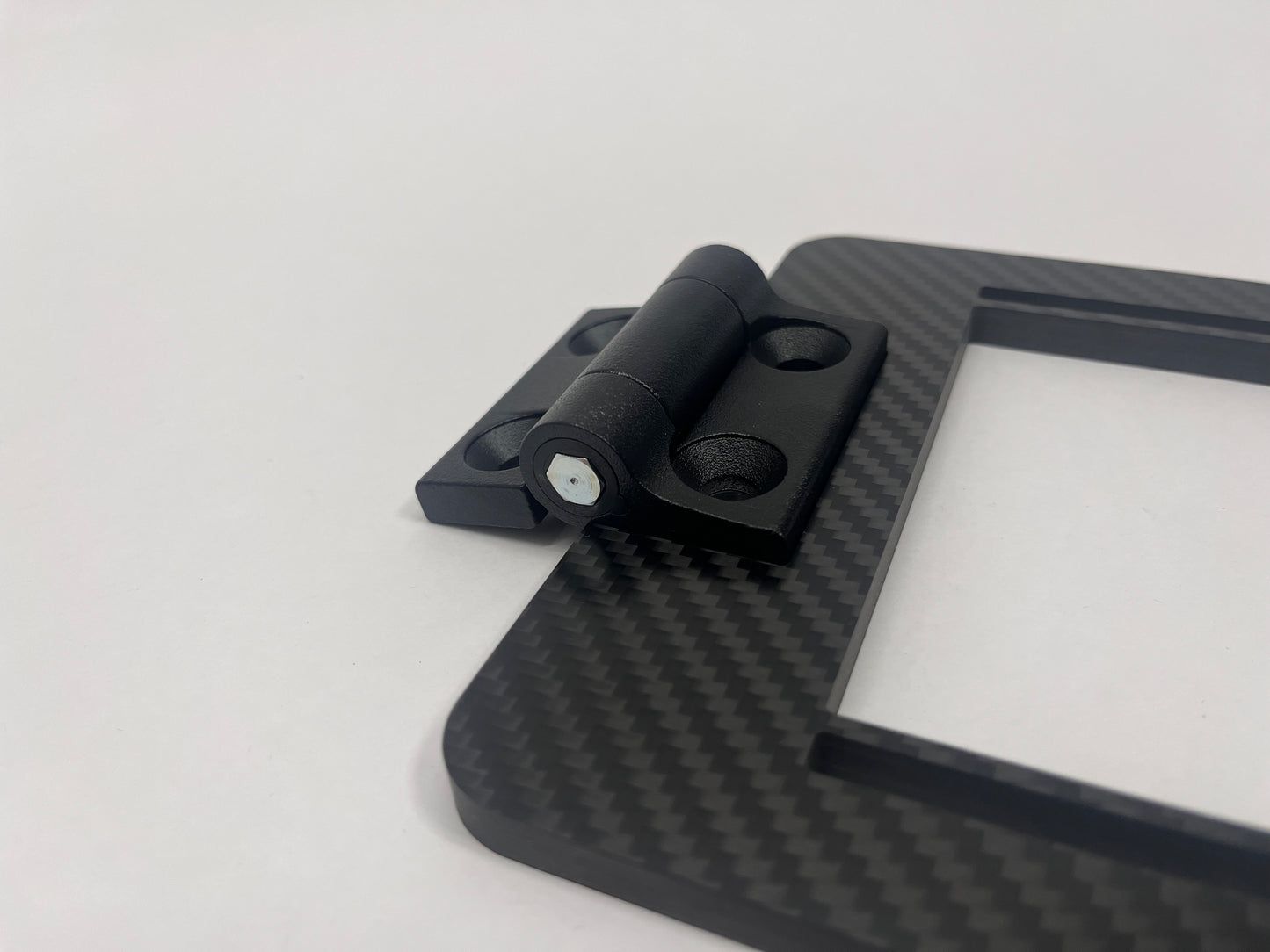 Black metal hinge on a carbon expansion bracket