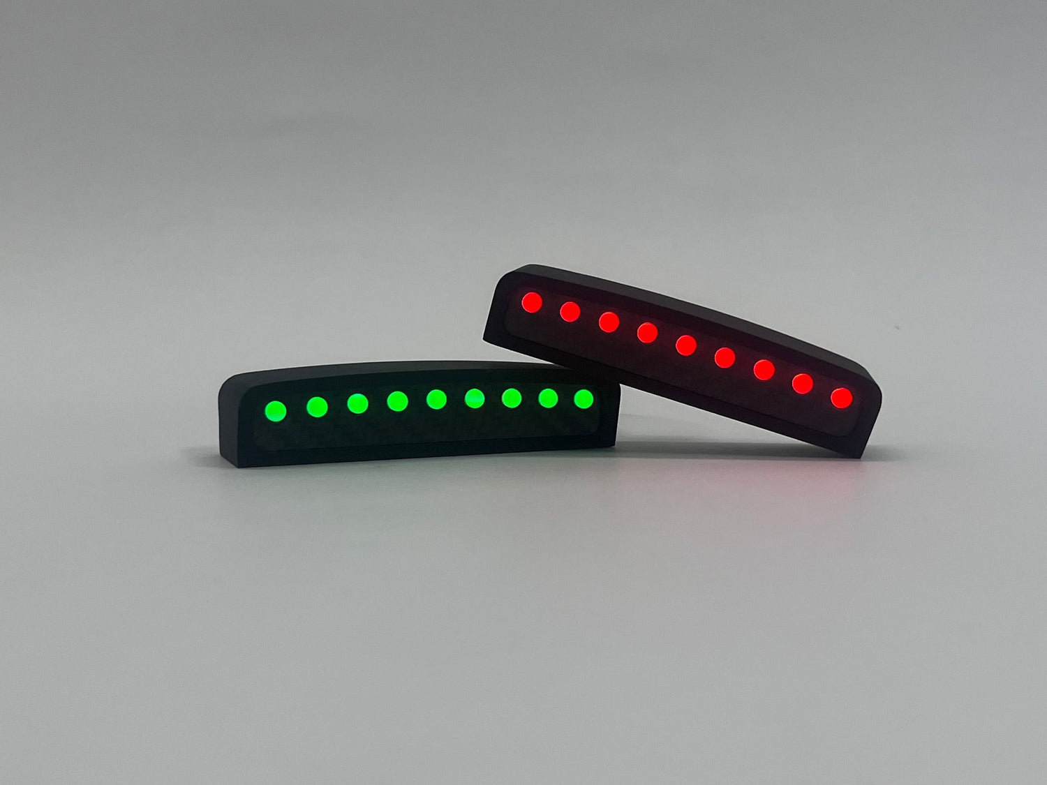 Two LED light bars, one green and one red, on a gray background