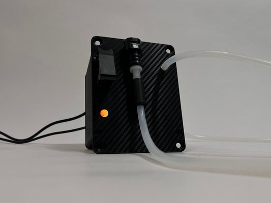 Sim Racing Hydration Drink Button Box module shown from bottom looking up at it. Orange LED on with silicone tubing attached to it on a light gray background