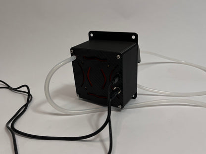 rear of the src drinkbox drinking unit for sim racing showing air cooling ducts with orange internals and a carbon fiber texture back plate. Silicone white tubing and black cables coming out of the back. On a light gray background