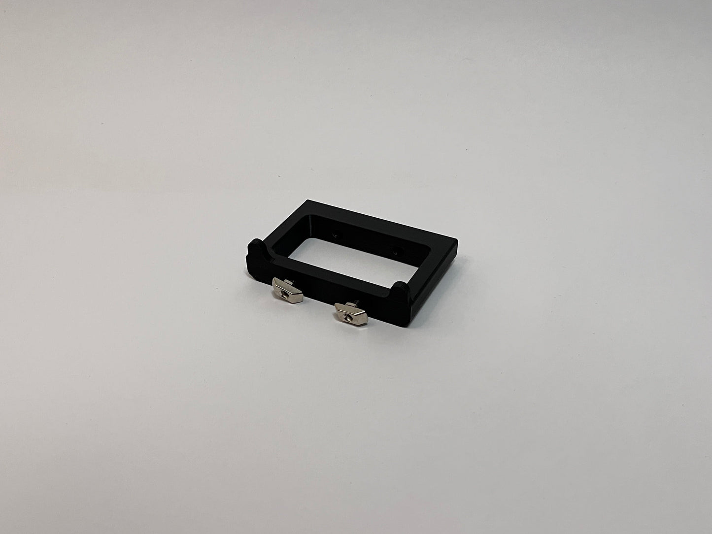 rear view of the button box solid mount showing 4040 profile mounting hardware installed on the mount on a white background