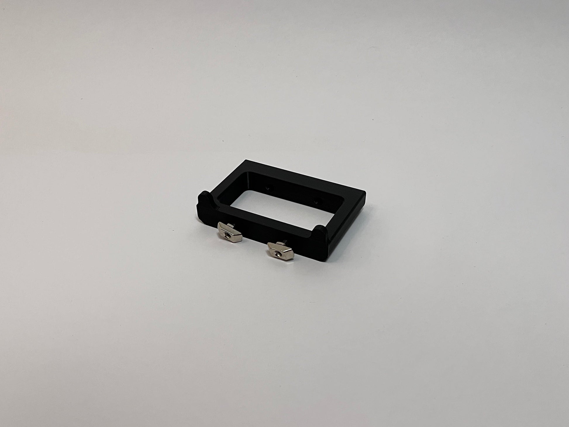rear view of the button box solid mount showing 4040 profile mounting hardware installed on the mount on a white background