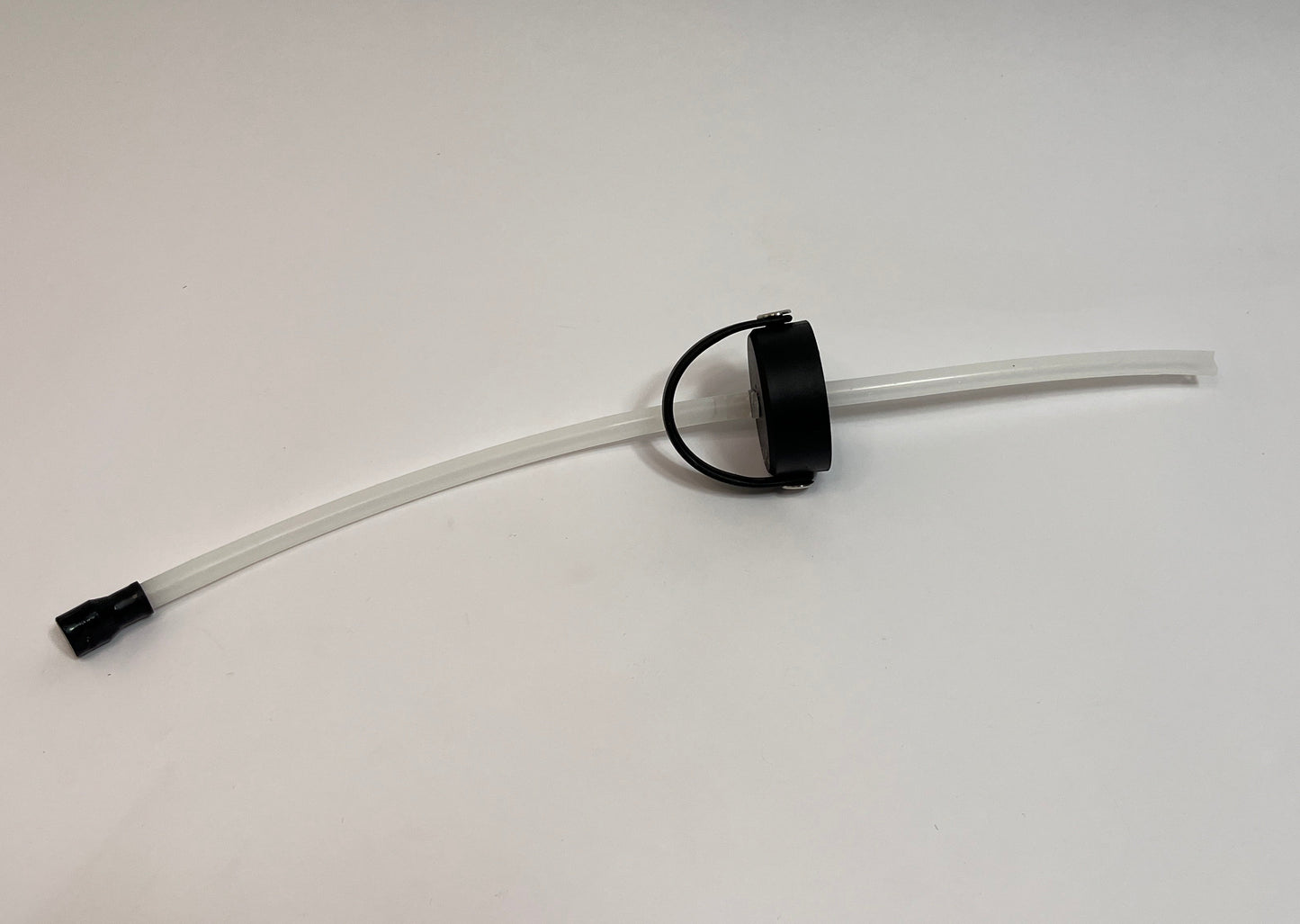 Sipping cap showing black cap with white silicone tubes on both sides with a black silicone bite valve on one side of the tubing on a white background