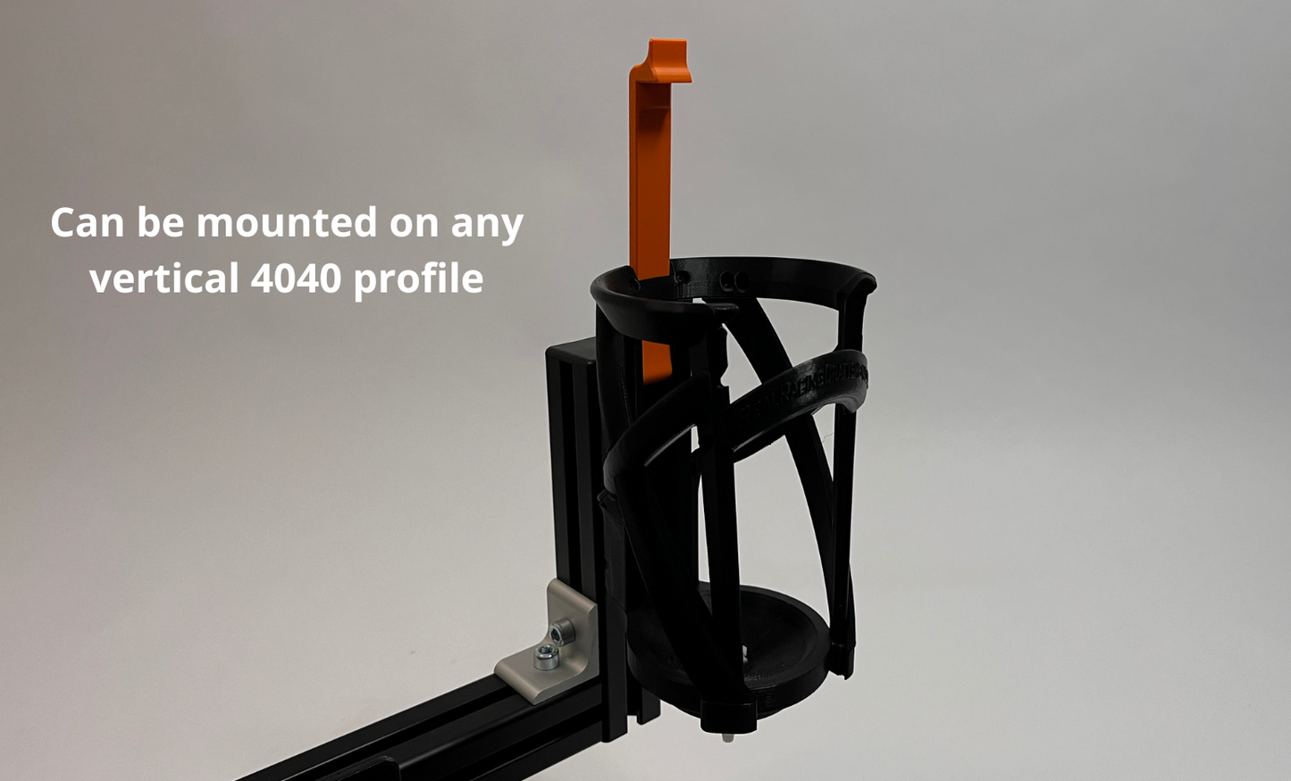 Black lattice bottle cage for sim racing based on real racing version mounted on 4040 profile, shown on a light gray background with white text that reads 'Can be mounted on any vertical 4040 profile'.