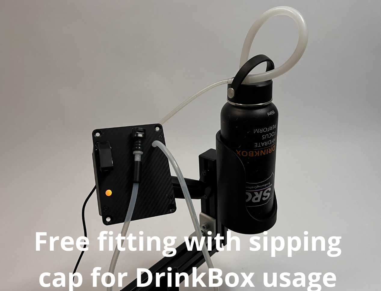 A black insulated bottle with a white sipping tube connected to a DrinkBox and black mounting bracket, shown against a light gray background with overlaid text reading 'Free fitting with sipping cap for DrinkBox usage.'.