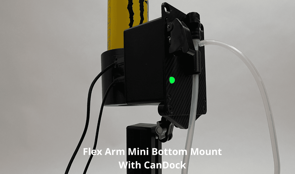 A black Flex Arm Mini Bottom Mount with CanDock mounted on sim racing drink unit, shown holding a yellow Monster Energy can and a clear tube, on a light gray background with white text overlay.