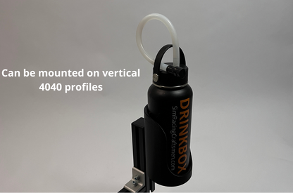 A black Drinkbox water bottle with a straw cap, shown mounted on a vertical bracket against a gray background, with white text reading 'Can be mounted on vertical 4040 profiles'.